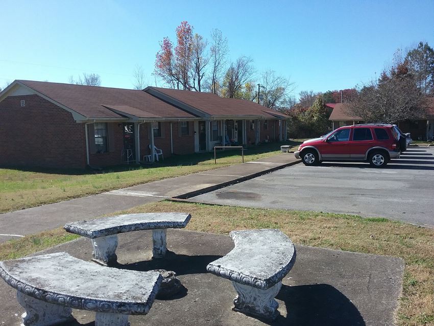 a picnic table and benches in front of a building
